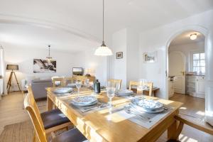 a dining room and living room with a wooden table at Paulas Hues Paula in Keitum