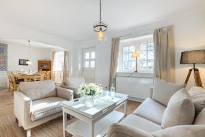 a living room with white furniture and a table at Paulas Hues Paula in Keitum