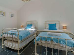 - 2 lits dans une chambre avec des oreillers bleus dans l'établissement 3 Bed in Lamphey 82584, à Lamphey