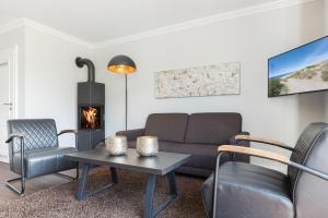 un salon avec un canapé et une cheminée dans l'établissement Suederwind 2, à Keitum