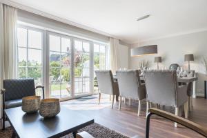 un salon avec une table et des chaises et une salle à manger dans l'établissement Suederwind 2, à Keitum 11 autres photos