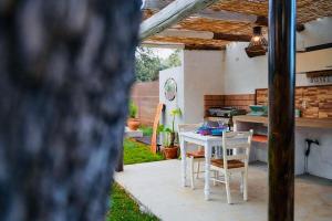 uma cozinha com mesa e cadeiras num quintal em Villa Experience Rural em Ronda