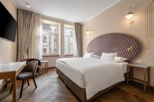 a hotel room with a large bed and a desk at Grand Hotel Union Eurostars in Ljubljana