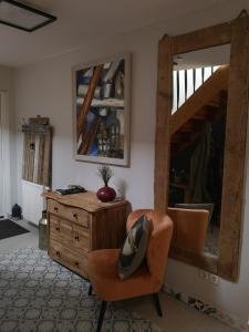 a room with a mirror and a chair and a dresser at Pension Trent in Trent