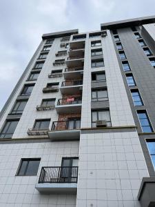 um edifício de apartamentos branco e alto com varandas em Mirabad City - 2 em Yakkasaray