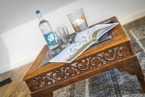 a wooden table with a bottle and books on it at Sueder Ech in Keitum