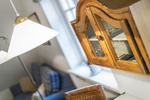 a living room with a mirror and a lamp at Sueder Ech in Keitum +9 photos