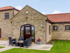 a stone house with a patio with chairs at 2 bed property in Hamsterley 80003 in High Etherley