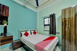 a bedroom with a bed with blue walls and a window at OYO Flagship Hotel R P Royal in Patna