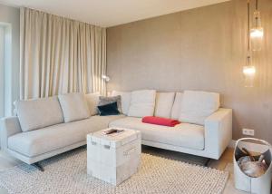 a living room with a white couch and a table at Smuk Hus in Hörnum