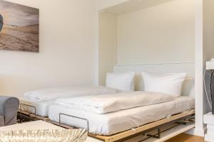 two beds in a room with white walls at Uaster Reeg I Parterrewohnung in Archsum