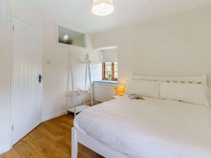 a white bedroom with a white bed and a window at 1 bed property in Nantyglo 82705 in Nantyglo
