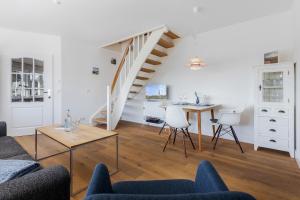 a living room with a staircase and a table and chairs at Blue Haven in Keitum +17 photos