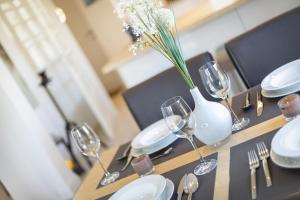 una mesa con copas de vino y un jarrón con flores en Gode Tiet, en Westerland