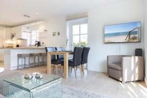 a kitchen and living room with a table and chairs at Gode Tiet in Westerland (Sylt)
