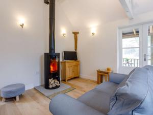 a living room with a blue couch and a wood stove at 1 bed in Sherborne 80737 in Wootton Glanville