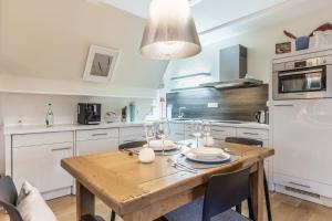 a kitchen with a wooden table with wine glasses at Kleines Nest 40 Wattkueken 41 in Keitum