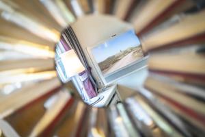 a mirror reflection of a room with a window and books at Kleines Nest 40 Wattkueken 41 in Keitum