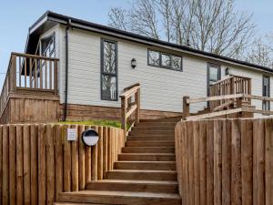 a house with a wooden fence and stairs leading to it at 2 Bed in South Molton 82260 in Romansleigh