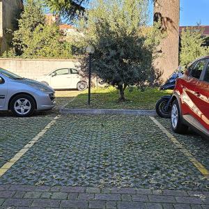 twee geparkeerde auto's geparkeerd op een parkeerplaats bij Casa Moderna Olgiate in Olgiate Olona