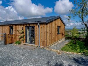 a wooden building with a door in a driveway at 2 Bed in Bentham 82857 in High Bentham