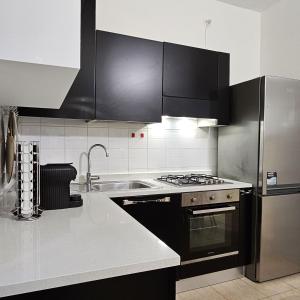 una cocina con electrodomésticos de acero inoxidable y armarios negros en Casa Moderna Olgiate, en Olgiate Olona