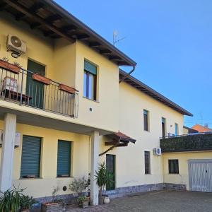 een geel huis met een balkon bij Casa Moderna Olgiate in Olgiate Olona