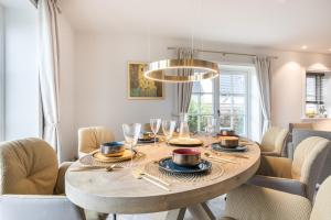 a dining room table with chairs and a chandelier at Traumblick Sylt in Rantum