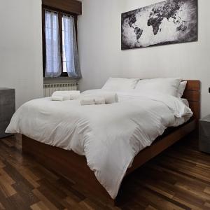 een slaapkamer met een groot bed met witte lakens bij Casa Moderna Olgiate in Olgiate Olona