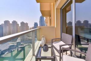 a balcony with chairs and a view of the city at Address Dubai Marina Suite Full Marina View with Balcony in Dubai