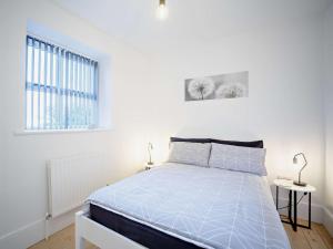 a white bedroom with a bed and a window at 3 bed in Hamsterley 81503 in Evenwood