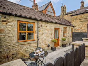 a stone house with a table and chairs in front of it at 3 bed in Hamsterley 81503 in Evenwood