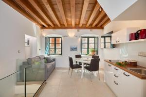 a kitchen and living room with a table and a couch at B18 APARTMENT in Dubrovnik