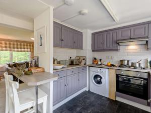 a kitchen with purple cabinets and a washing machine at 2 Bed in Woodgreen 82875 in Godshill