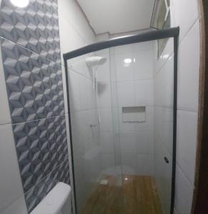 La salle de bains est pourvue d'une douche avec une porte en verre. dans l'établissement Solo Nunes, à Manaus