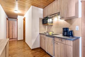 uma cozinha com armários de madeira e uma bancada em Schwüwong - Apartment 12 em Kelchsau