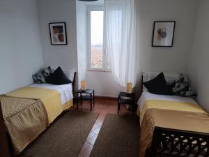 a hotel room with two beds and a window at Agriturismo Tenuta la Marchesa in Novi Ligure