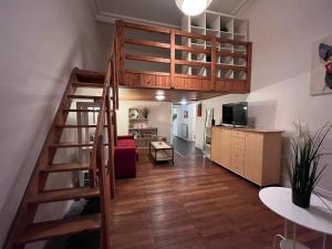uma sala de estar com uma cama alta e uma cozinha em Le Berriat YourHostHelper em Grenoble