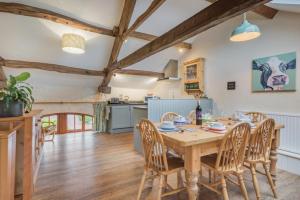 a kitchen and dining room with a wooden table and chairs at 3 Bed in Eden Valley SZ400 in Kirkoswald