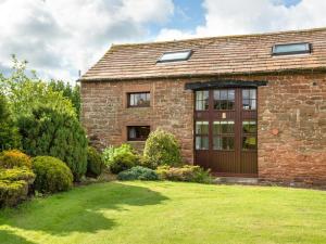 a brick house with a large window and a yard at 3 Bed in Eden Valley SZ400 in Kirkoswald