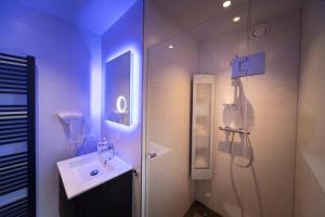 een badkamer met een douche, een wastafel en een douche bij 't Eekhoornnest in Soest