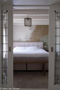 a bedroom with a bed and a glass door at Herberg de Zwaan Elspeet in Elspeet