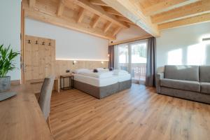 a large room with a tub and a couch at Rifugio La Para in San Vigilio Di Marebbe