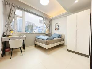 a bedroom with a bed and a desk and window at Student Accommodation - 5 Man Cheong Street in Hong Kong