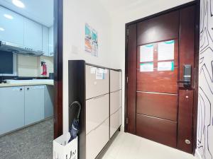 a brown door in a kitchen next to a refrigerator at Student Accommodation - 5 Man Cheong Street in Hong Kong