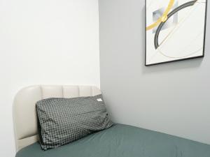 a white couch with a pillow next to a wall at Student Accommodation - 5 Man Cheong Street in Hong Kong