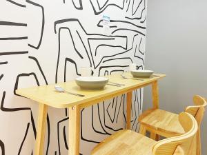 a wooden table with two bowls on it in front of a wall at Student Accommodation - 5 Man Cheong Street in Hong Kong