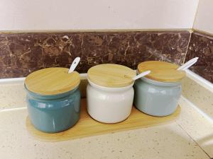 three jars on a wooden shelf in a kitchen at Student Accommodation - 5 Man Cheong Street in Hong Kong