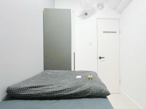 a bed with a teddy bear sitting on top of it at Student Accommodation - 5 Man Cheong Street in Hong Kong