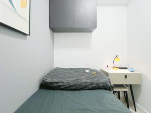 a small bedroom with a bed and a desk at Student Accommodation - 5 Man Cheong Street in Hong Kong